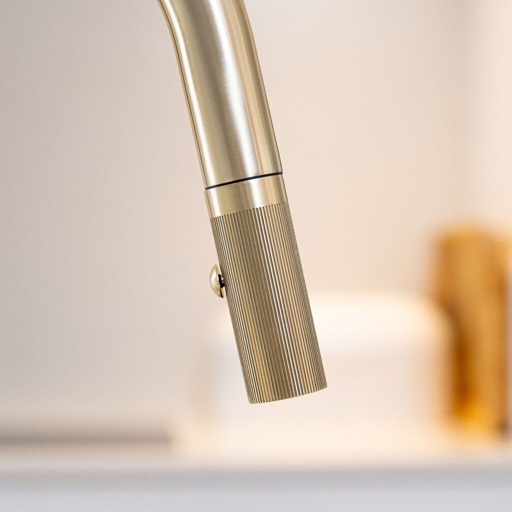 Quel Ultra Plus 4-in-1 instant boiling water tap in brushed brass, close-up of the docked pull-out spray head showing its textured grip and integrated spray control button.